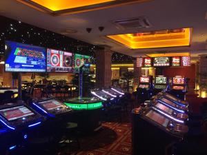 ein Casino mit vielen Spielautomaten und Pokertischen in der Unterkunft Casino & Hotel Admiral Strážný in Strážný