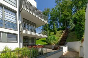 a house with a balcony and a stairway at Villa Paula in Sellin - WG01 "Findling" strandnah mit Kamin, Terrasse, Balkon in Ostseebad Sellin