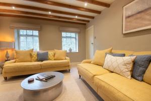 ein Wohnzimmer mit zwei Sofas und einem Couchtisch in der Unterkunft Riverside Cottage Alstonefield Peak District in Alstonfield