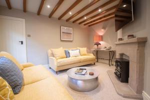 ein Wohnzimmer mit Couch und Kamin in der Unterkunft Riverside Cottage Alstonefield Peak District in Alstonfield