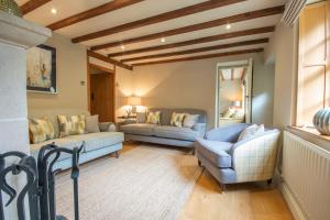 ein Wohnzimmer mit 2 Sofas und einem Fenster in der Unterkunft Riverside Cottage Alstonefield Peak District in Alstonfield + 11 Fotos