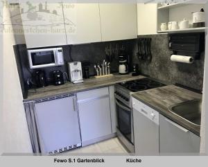 a kitchen with a stove and a microwave at Harz Fewo Eulennestchen S1 in Altenau