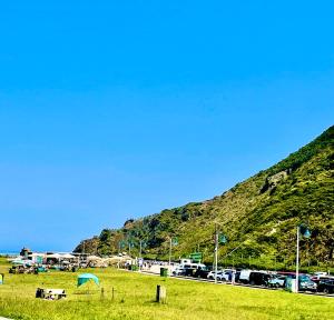 a green field with a hill in the background at Apartamento San Juan de la Arena con vistas al mar in San Juan de la Arena