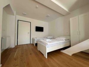a bedroom with two beds and a tv on the wall at AM1114 - Moderne Monteurwohnung Übergangswohnung in Amberg