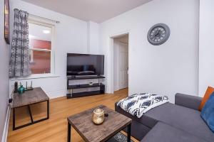 オタワにあるPet-friendly Apartment - Steps to Rideau Centreのソファとテレビのあるリビングルーム