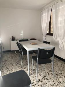 a dining room with a white table and chairs at Appartement moderne avec jardin à Coggia - 90m² - Vue magnifique in Coggia
