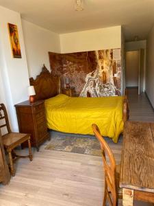 a bedroom with a bed with a yellow blanket at MMM soirée étape in La Séauve-sur-Semène +29 photos
