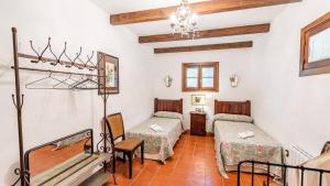 a room with two beds and a table at Casa Huerta de la Fuente Hornachuelos by Ruralidays in Hornachuelos +29 photos