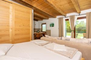 a bedroom with a white bed and a wooden ceiling at Nature Holiday Home in Grižane