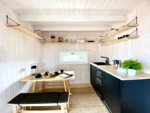 a kitchen with a counter and a table in it at Japandi Guesthouse in Muhu in Võiküla