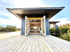 a wooden deck with awning on a house at Japandi Guesthouse in Muhu in Võiküla