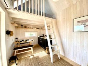 a tiny house with a ladder and a desk at Japandi Guesthouse in Muhu in Võiküla
