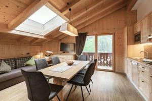a kitchen and dining room with a table and chairs at Apartments Burvel in Selva