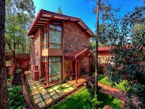 a brick house with a gazebo in a yard at Sereno Barn Eco Stay Chikmagalur in Chikmagalūr
