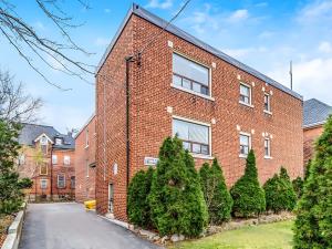 a red brick building with trees in front of it at Cozy Studio Apt - Corktown Hamilton in Hamilton