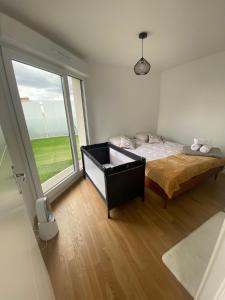 Un dormitorio con una cama y una ventana grande. en Le 147 Parc Entre Paris et Disney, en Champigny-sur-Marne