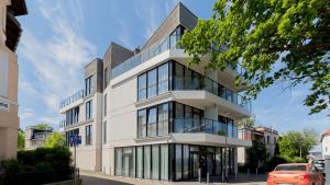 un bâtiment avec des fenêtres en verre sur une rue dans l'établissement VacationClub - Boulevard Residence Apartament 24, à Ustronie Morskie