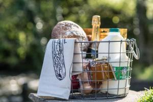 un panier rempli de nourriture et d'une bouteille de lait dans l'établissement Duck Cottage Milldale Alstonefield Peak District, à Alstonfield