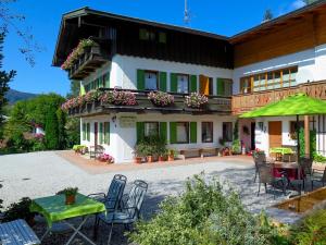 a house with a table and chairs in front of it at Ferienwohnung Haus Rosenbichl GbR in Schönau am Königssee