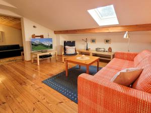 a living room with two orange couches and a television at Ferienwohnung Haus Rosenbichl GbR in Schönau am Königssee