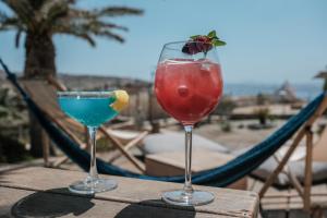 two cocktails sitting on a table with a hammock at Baba Houlakia in Houlakia