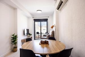 salon z drewnianym stołem i krzesłami w obiekcie Apartamentos Marina Playa de Torrevieja by Apartamentos Torrevieja w mieście Torrevieja