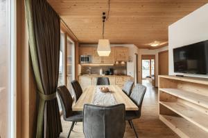 a kitchen and dining room with a wooden table and chairs at Apartments Burvel in Selva +23 photos