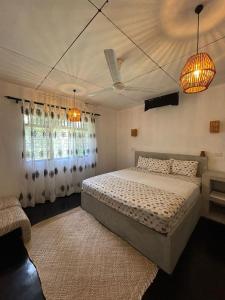 a bedroom with a large bed and two windows at Sri Villa Polwatta in Weligama