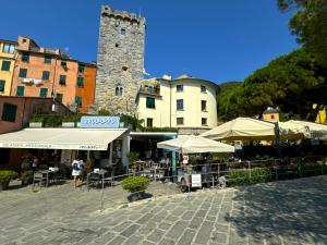 a patio with tables and umbrellas in front of a building at La Casa Rotonda in Portovenere