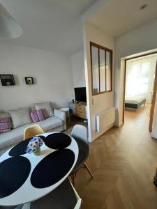 a living room with a table and a couch at Appartement moderne et cosy , 5 min de la gare de RER D , remise des clés en main propre in Alfortville