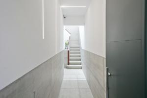 un couloir d'une maison avec des murs blancs et une porte dans l'établissement Boutique Plaza Catalonia Suites Cornellá, à Cornellà de Llobregat
