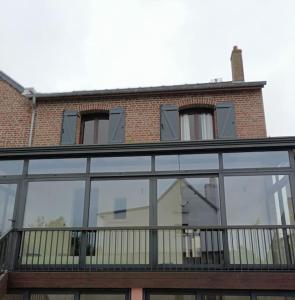 a building with glass windows and a balcony at Villa Monette -Le Crotoy in Le Crotoy