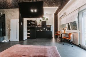 a living room with a table and a kitchen at Stari Toranj V studio apartman in Vukovar