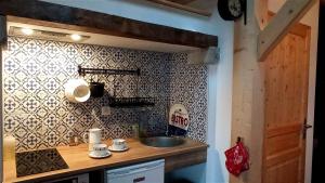 - une cuisine avec un évier et un mur en carrelage dans l'établissement Transhumance & cie, Auberge, Appartements & SPA, à Bedous 84 autres photos