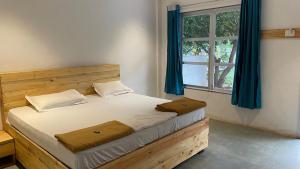 a bedroom with a wooden bed with a window at pra tiksha farm in Karjat +99 photos