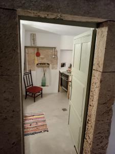 an open door to a kitchen with a red chair at Latmos 1860 in Skala