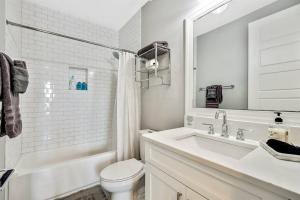 a white bathroom with a sink and a toilet at Luxury Living Superior Home in Prime Tampa Location in Tampa +10 photos