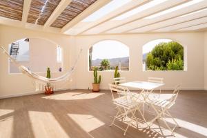 a room with a hammock and a table and chairs at TrendyHomes Los Cinco Arcos in Níjar