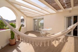 a hammock in a living room with a patio at TrendyHomes Los Cinco Arcos in Níjar
