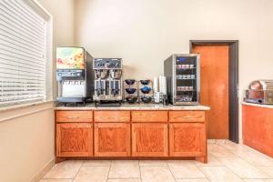 a kitchen with a counter with several coffee machines at Ramada by Wyndham College Station in College Station