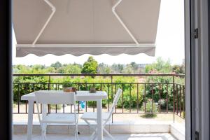 a white table and chairs on a balcony at Iris apartment by the sea in Epanomi +5 photos