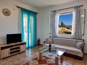 a living room with a couch and a television at Maspali Apartments in Lixouri