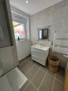 a bathroom with a sink and a tv on the wall at Apparemment T2 en centre ville in Gournay-en-Bray