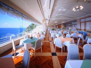 a restaurant on a cruise ship with tables and chairs at Dogashima New Ginsui in Nishiizu