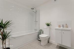 a bathroom with a tub and a toilet and a sink at StarHost Residences - Brand New 2 bed apartment in Newbury Centre in Newbury +26 photos