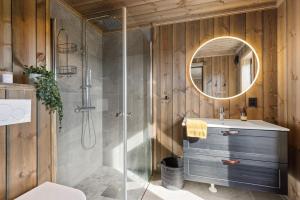 a bathroom with a shower and a sink and a mirror at Ny eksklusiv hytte, strøm og jacuzzi inkl i prisen in Flå +44 photos