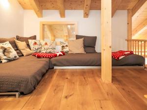 a large couch in a room with a wooden floor at Chalet La Bergerie by Interhome in Nendaz