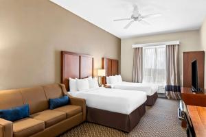 una camera d'albergo con due letti e un divano di Comfort Inn & Suites Grenada a Grenada Altre 60 foto