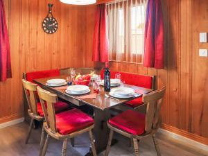 - une table à manger avec des chaises rouges et une bouteille de vin dans l'établissement Chalet Dorine by Interhome, à Nendaz 33 autres photos