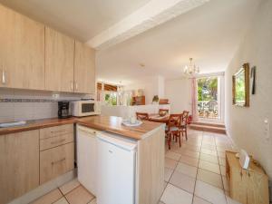 a kitchen with wooden cabinets and a table with chairs at Holiday Home Bonita by Interhome in Cala Anguila